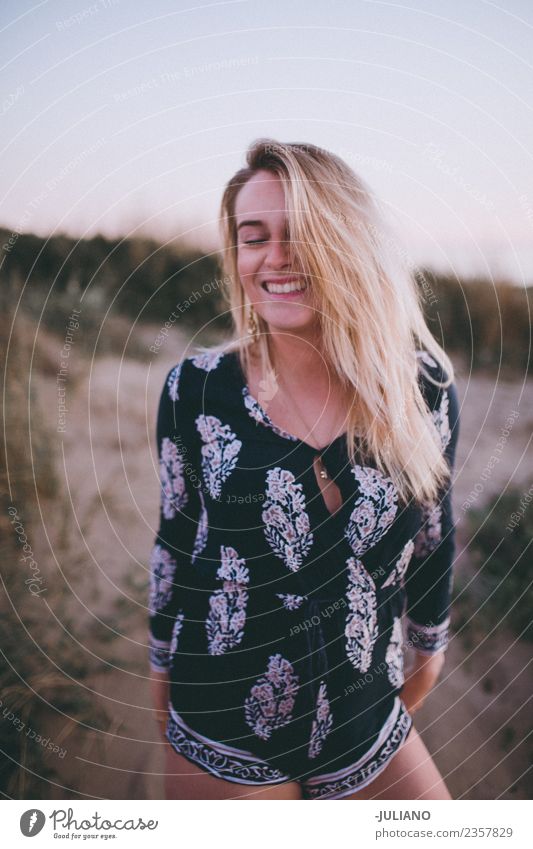 Junge Frau lacht am Strand. Sonne blond Coolness Abenddämmerung Freude Mädchen Güte lachen Lifestyle Meer retro Sand Lächeln Sommer Sommerfreunde