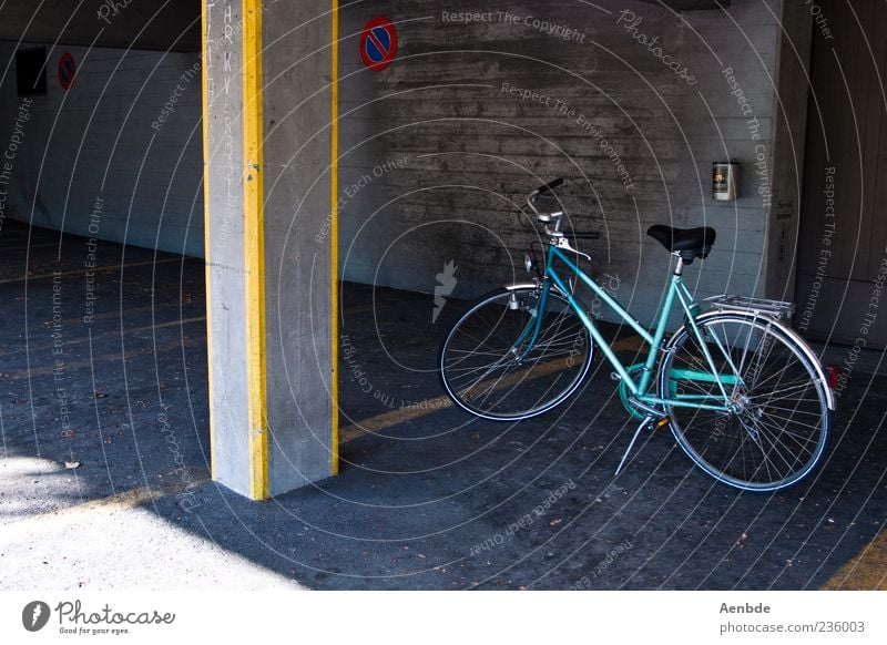 Parken Fahrrad parken Parkplatz Parkhaus Säule gelb blau Damenfahrrad Farbfoto Außenaufnahme Menschenleer Tag Asphalt Schatten Sonnenlicht