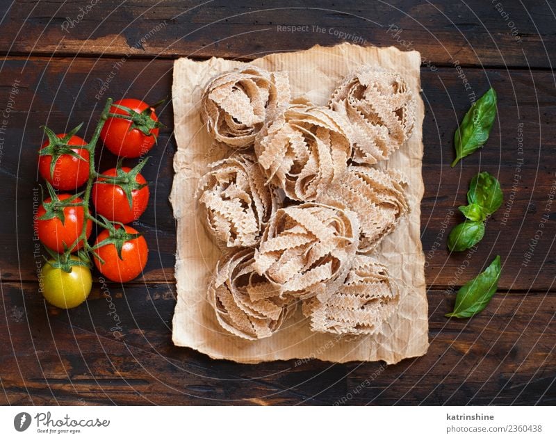 Vollkornnudeln Tagliatelle, Tomaten und Basilikum Vegetarische Ernährung Diät Tisch Blatt dunkel frisch braun grün rot Tradition Essen zubereiten Lebensmittel