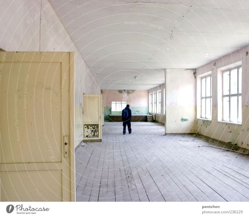 Rückansicht eines Mannes, der in einer großen, verfallenen, Altbauwohnung steht. Holzdielen. Lost place maskulin 1 Mensch Haus Ruine Bauwerk Gebäude Fenster Tür