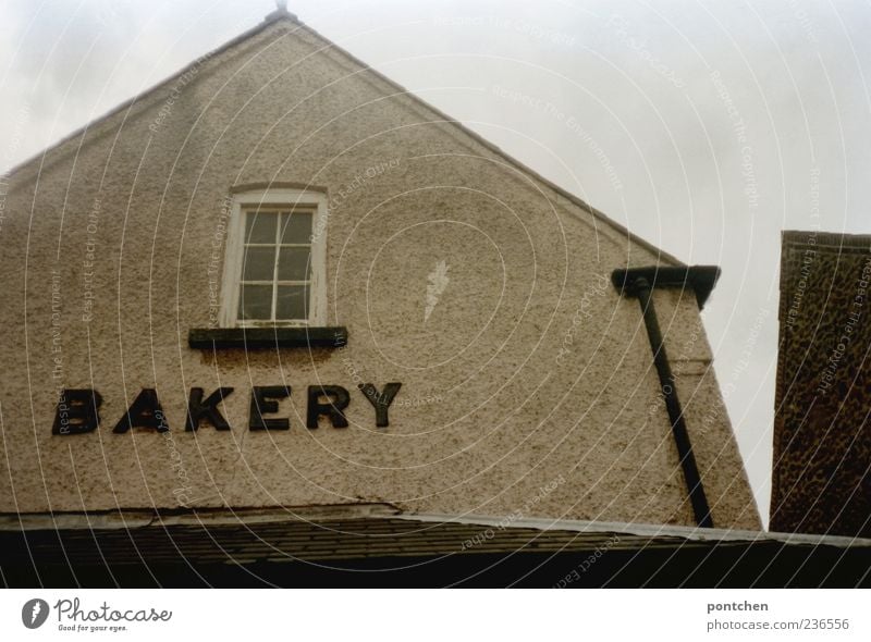 Ein altes Haus mit Aufschrift bakery Himmel Wolken schlechtes Wetter hunstanton England Dorf Bauwerk Gebäude Architektur Dach Dachrinne Englisch Wort Fenster