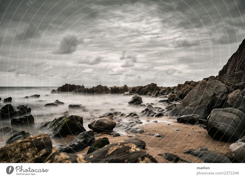 steiniger Strand Landschaft Sand Wasser Himmel Wolken Horizont Sommer Wetter schlechtes Wetter Wind Felsen Wellen Küste Bucht Meer Menschenleer dunkel braun