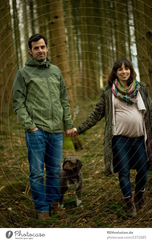 Paar geht im Wald spazieren Blick nach vorn Ganzkörperaufnahme Totale Schwache Tiefenschärfe Unschärfe Schatten Tag Außenaufnahme Farbfoto Spaziergang Babybauch