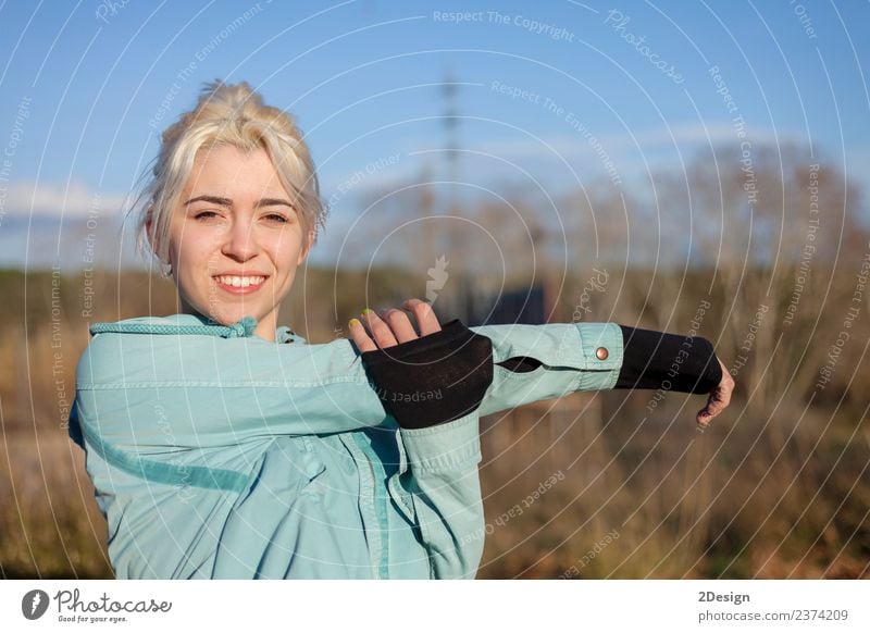 Eine schöne junge blonde Frau, die sich in einem Park ausstreckt. Lifestyle Glück Körper Sport Leichtathletik Sportler Joggen Mensch feminin Junge Frau