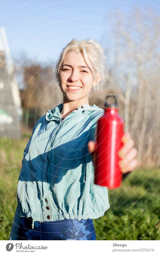 Läuferin, die im Freien steht und eine Trinkflasche hält. trinken Flasche Lifestyle Glück schön Wellness Erholung Sommer Sport Joggen Mensch feminin Junge Frau