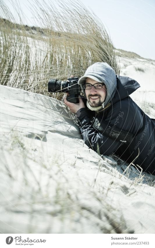 Spiekeroog | Piraculi Mensch maskulin Junger Mann Jugendliche Erwachsene 1 18-30 Jahre Pflanze Sand Wind Lächeln Freude Fotograf Fotografieren kalt Dünengras