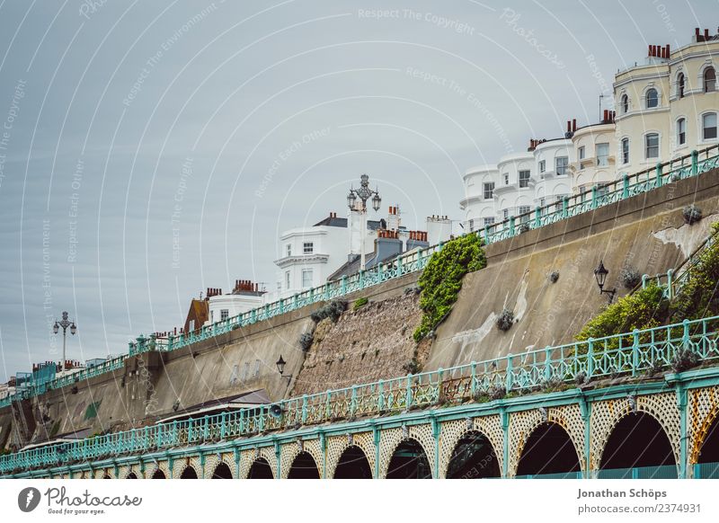 Strandpromenade Küste Brighton Torbögen Bögen steil Stadtrand wohnen England trüb Geländer türkis Mauer wall