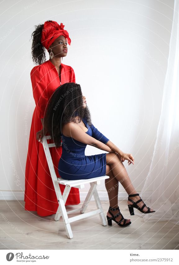 Arabella und Apolline Stuhl Raum Vorhang Gardine feminin Frau Erwachsene 2 Mensch Kleid Ohrringe Damenschuhe brünett langhaarig Locken Afro-Look beobachten