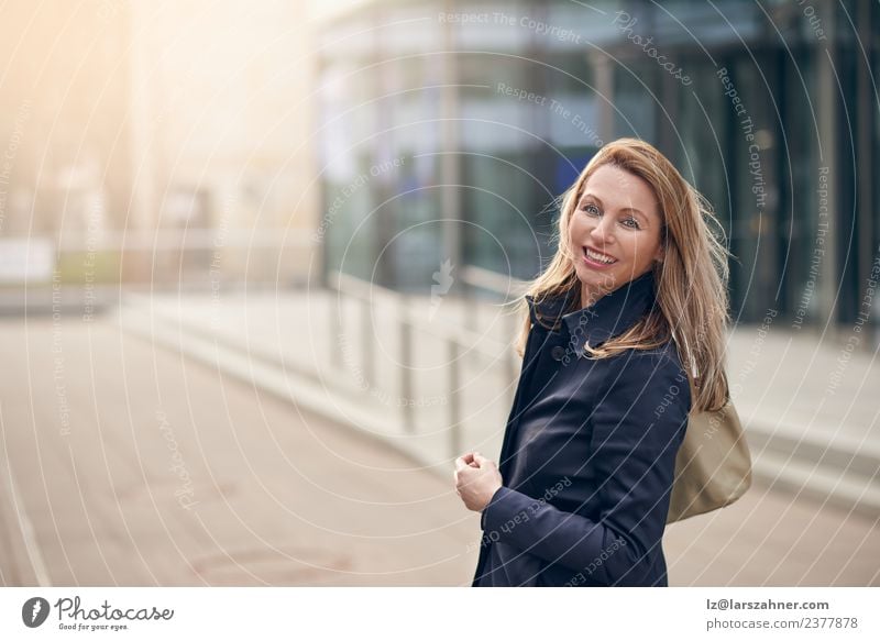 Fröhlich lächelnde Frau im Wind stehend Glück Business Erwachsene 1 Mensch 45-60 Jahre Gebäude Straße blond Lächeln lachen Freude Fröhlichkeit Frühlingsgefühle