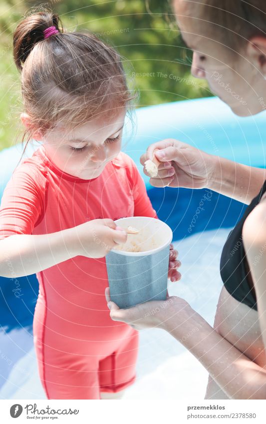 Teenagermädchen mit ihrer kleinen Schwester, die Zeit miteinander verbringt. Dessert Speiseeis Essen Lifestyle Freude Glück schön Schwimmbad Freizeit & Hobby