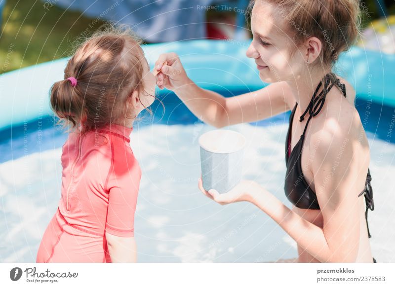 Teenager Mädchen mit ihrer kleinen Schwester genießen es, Eis zu essen. Dessert Speiseeis Essen Lifestyle Freude Glück schön Schwimmbad Freizeit & Hobby