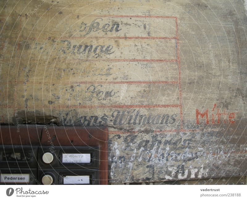 Zeitreise Gebäude Mauer Wand Namensschild Klingel Stein Holz Metall Schriftzeichen alt dreckig authentisch braun rot schwarz weiß Verfall Farbfoto Außenaufnahme