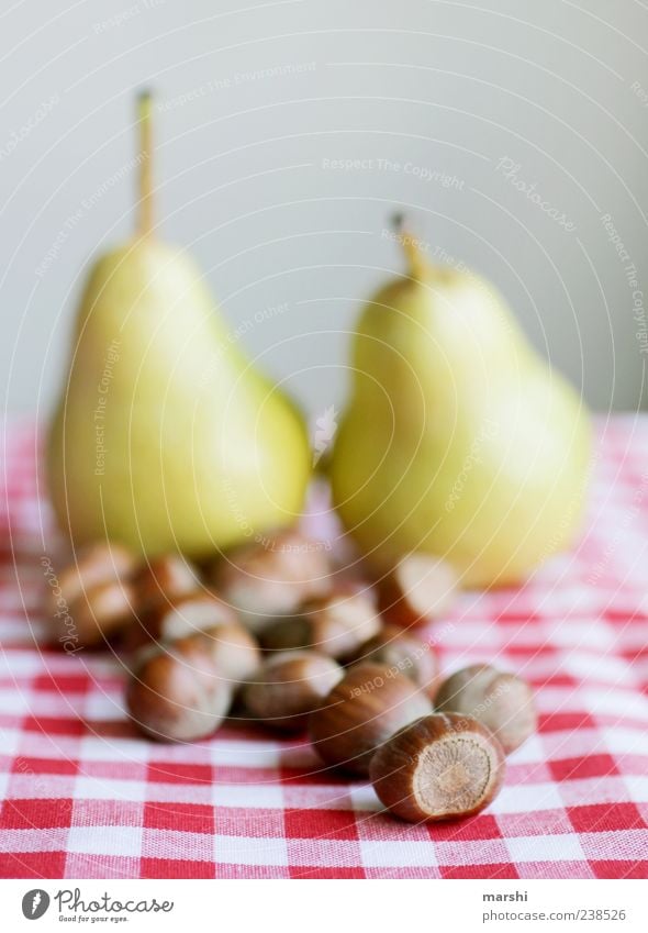 Haselnuss und Birne Lebensmittel Frucht Ernährung braun rot Nuss kariert Stillleben Unschärfe arrangiert Farbfoto Innenaufnahme Tischwäsche