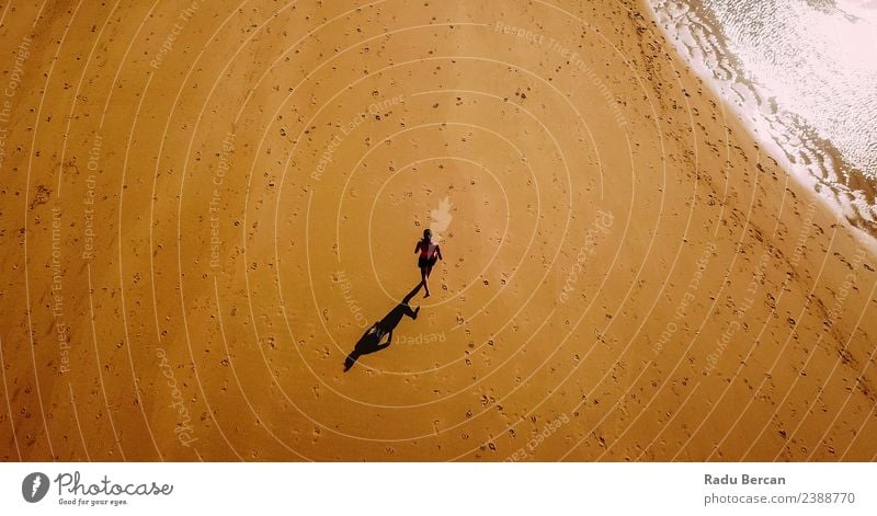 Luftaufnahme der sportlichen Frau, die am Strand läuft. Fitness Abenteuer Sommer Meer Sport Sport-Training Sportler Joggen Mensch feminin Junge Frau Jugendliche