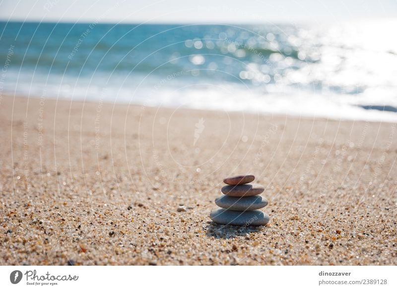 Steine stapeln sich auf dem Sand. Wellness harmonisch Erholung Meditation Spa Sommer Strand Meer Natur Himmel Horizont Felsen Küste natürlich blau schwarz weiß