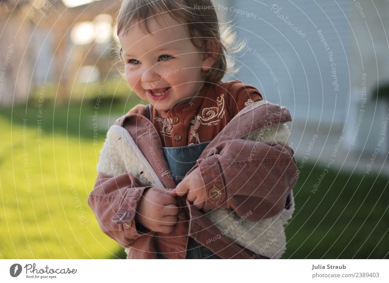 Jacke raus, der Frühling ist da feminin Kleinkind 1 Mensch 1-3 Jahre Schönes Wetter Wiese Latzhose Weste lammfell brünett Bewegung Lächeln lachen leuchten frech