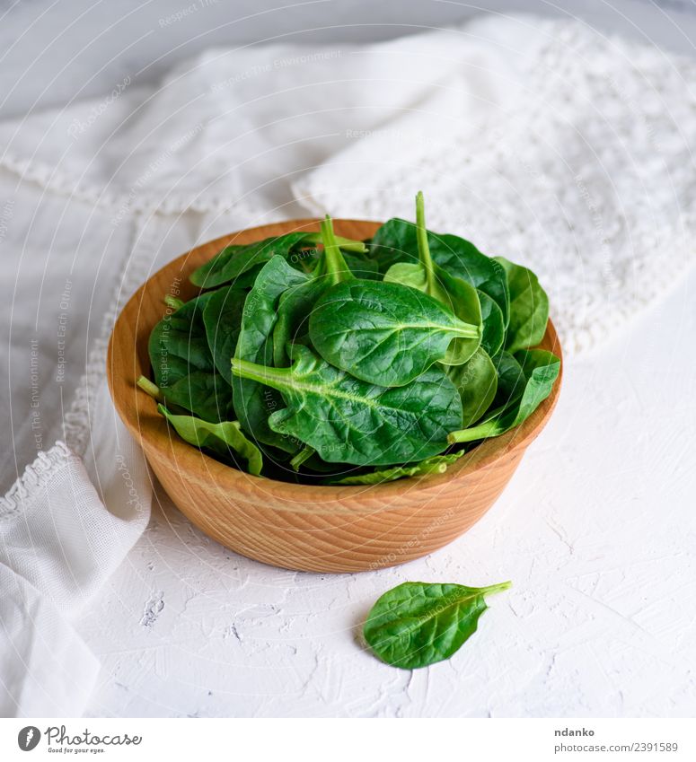 grüne Spinatblätter Gemüse Salat Salatbeilage Kräuter & Gewürze Vegetarische Ernährung Teller Schalen & Schüsseln Tisch Natur Pflanze Blatt Holz frisch