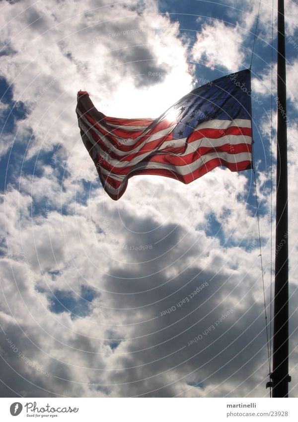 Stars and Stripes Fahne Wolken USA Himmel Trauerbeflaggung Gegenlicht Sonnenlicht durchleuchtet Wind wehen Wolkenhimmel