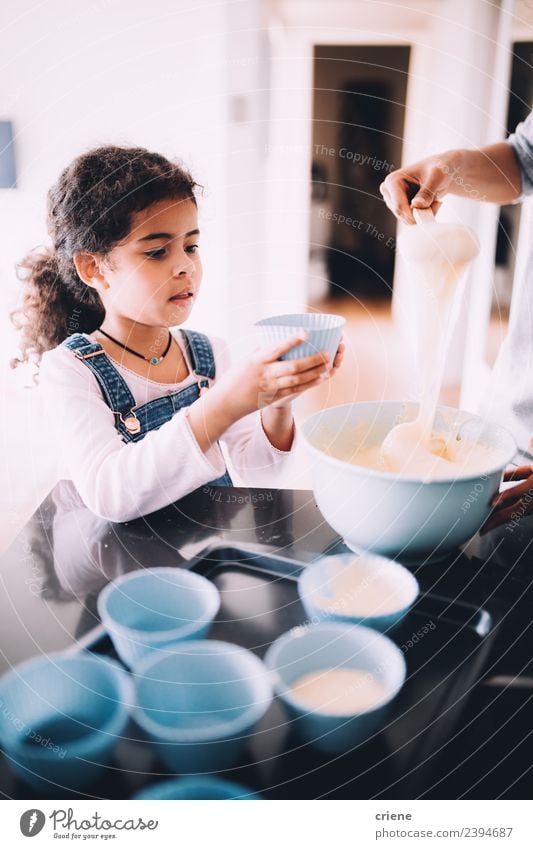 kleines afrikanisches Mädchen macht Muffins in der Küche. Dessert Schalen & Schüsseln Lifestyle Glück Kind Schule Frau Erwachsene Essen zubereiten backen