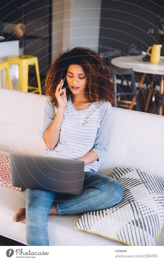 afrikanische Frau auf ihrem Handy beim Blick auf den Laptop Arbeit & Erwerbstätigkeit Business sprechen Telefon Computer Notebook Mensch Erwachsene Lächeln