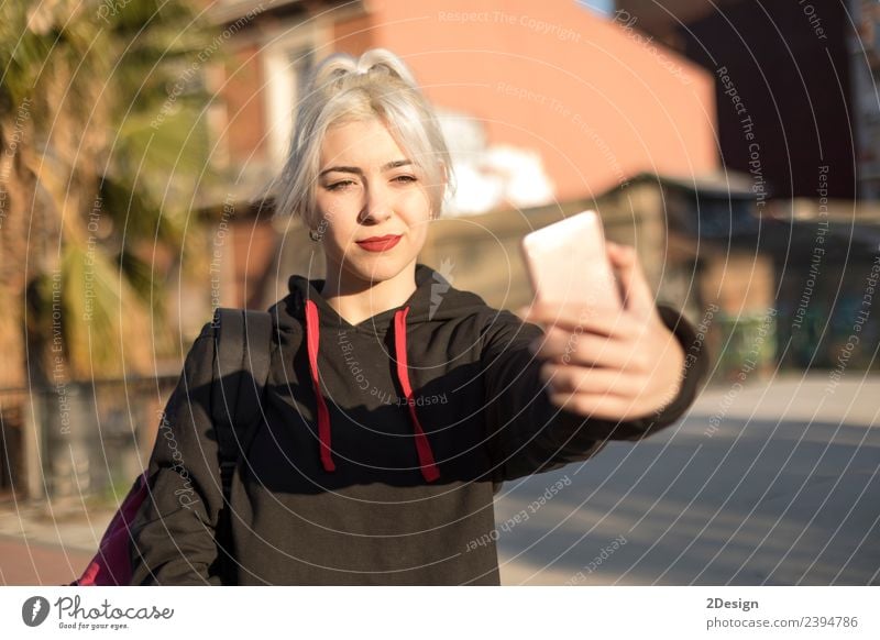 Junge Frau nimmt Selfie nach der Schule. Lifestyle Stil Freude Glück Erholung Berge u. Gebirge Schulhof Schulkind Schüler Telefon Handy PDA Fotokamera Mensch