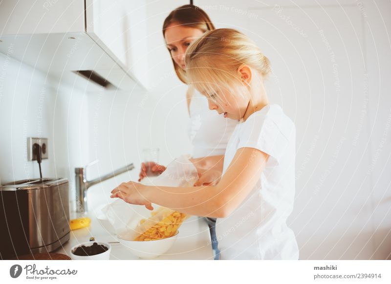 Mutter beim Frühstück mit der kleinen Tochter zu Hause Lifestyle Freude Glück Küche Kind Erwachsene Familie & Verwandtschaft Lächeln Umarmen Zusammensein modern