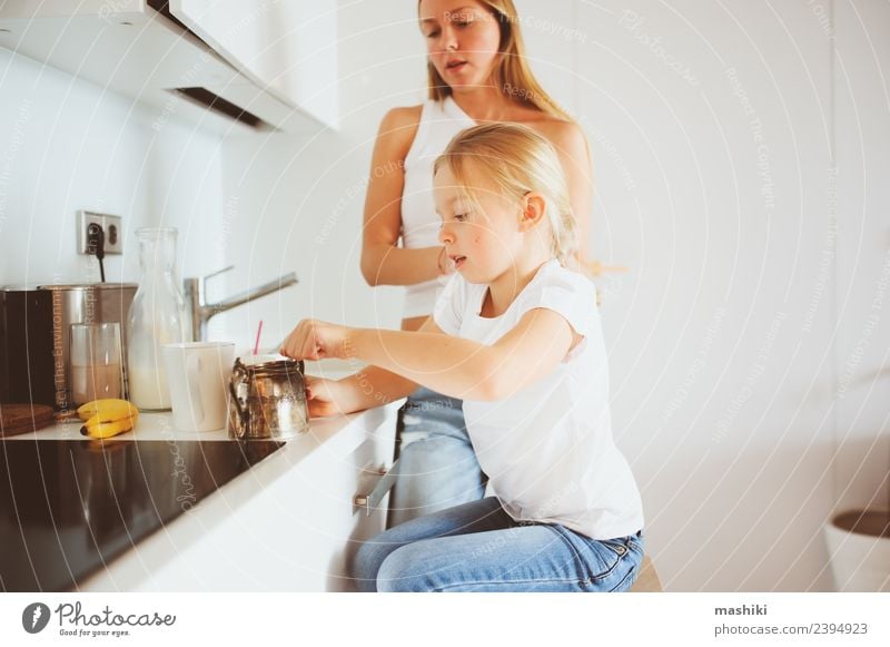 Mutter beim Frühstück mit der kleinen Tochter Lifestyle Freude Glück Küche Kind Erwachsene Familie & Verwandtschaft Lächeln Umarmen Zusammensein modern weiß