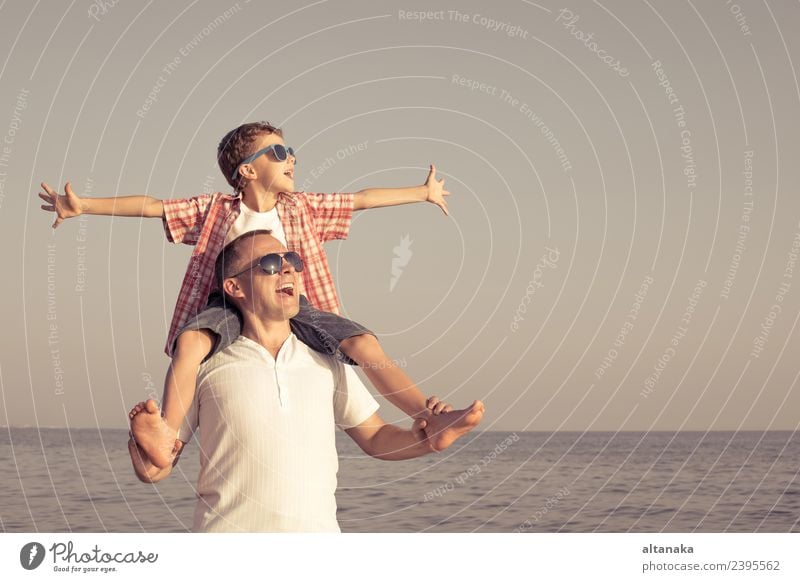 Vater und Sohn spielen zur Tageszeit am Strand. Die Menschen haben Spaß im Freien. Konzept des Sommerurlaubs und der freundlichen Familie. Lifestyle Freude