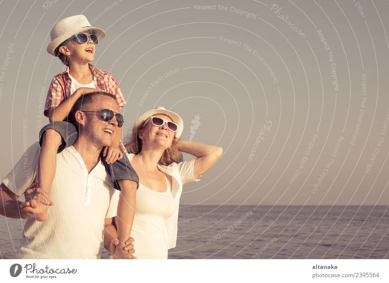 Glückliche Familie steht am Strand am Tag. Menschen, die Spaß im Freien. Konzept der Sommerurlaub und freundliche Familie. Lifestyle Freude Leben Erholung