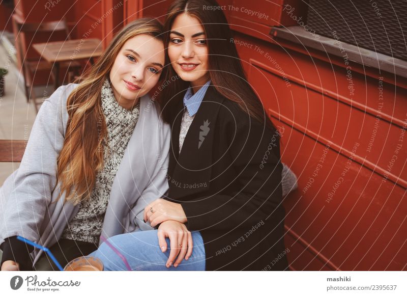 zwei glückliche Freundinnen im Gespräch Kaffee Lifestyle sprechen feminin Frau Erwachsene Freundschaft Herbst Wetter Straße Pullover Mantel Lächeln lachen