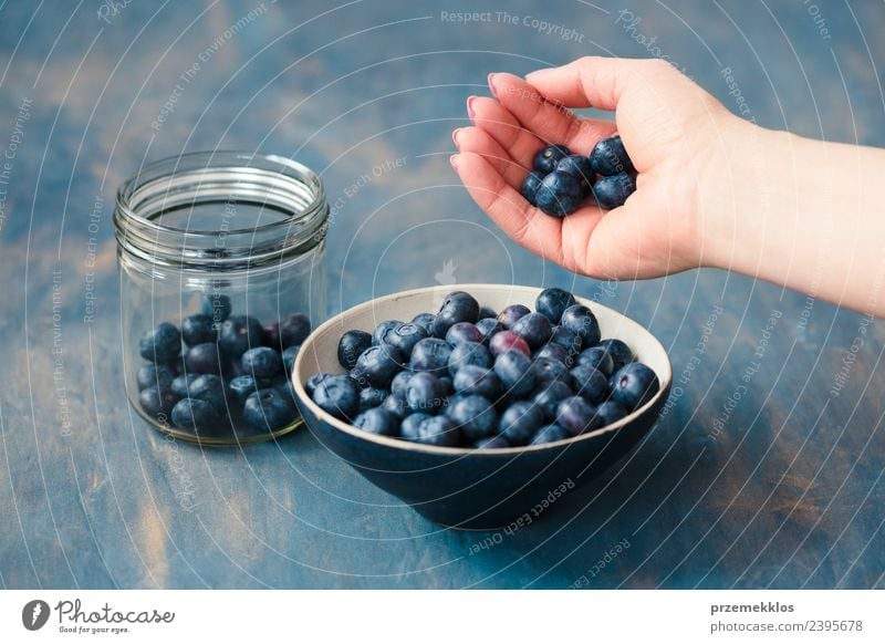 Frau, die frische Heidelbeeren aus einem Glas in eine kleine Schüssel legt. Frucht Ernährung Vegetarische Ernährung Schalen & Schüsseln Sommer Tisch Erwachsene