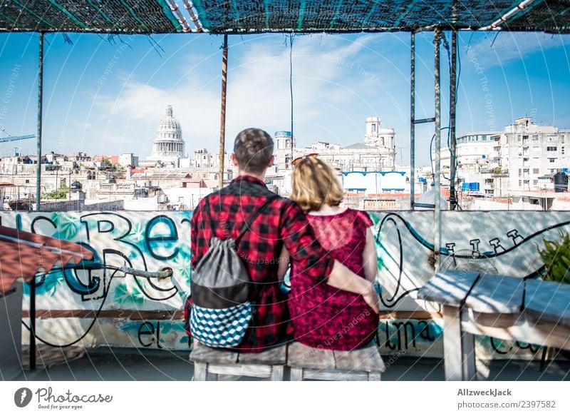 Paar sitzt auf einem Dach mit Blick aufs Kapitol in Havanna Kuba Skyline Aussicht Wohnhaus Wohnhochhaus Blauer Himmel Wolkenloser Himmel Sommer