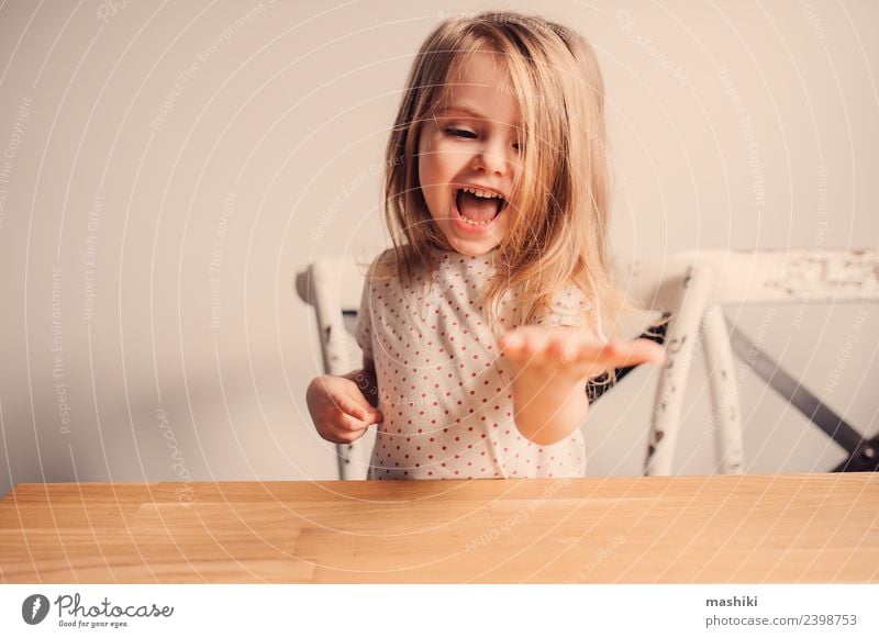 fröhliches Kleinkind-Mädchen im Pyjama, das in der Küche spielt. Freude Glück schön Spielen Kind Baby blond Lächeln lachen klein niedlich weiß reizvoll