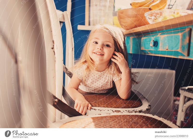 fröhliches Kleinkind-Mädchen im Pyjama, das in der Küche spielt. Freude Glück schön Spielen Kind Baby blond Lächeln lachen klein niedlich weiß reizvoll