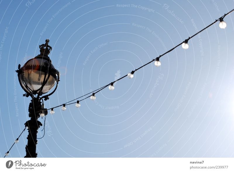 Lichterkette Lampe Kabel Wolkenloser Himmel leuchten blau Nostalgie Farbfoto Außenaufnahme Menschenleer Textfreiraum rechts Hintergrund neutral Tag Glühbirne