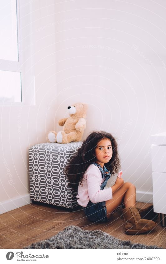 Afrikanisches Mädchen sitzt neben ihrem Teddybären zu Hause. Glück schön Kind Stiefel Spielzeug sitzen klein niedlich Bär heimwärts Raum Hintergrund Fenster