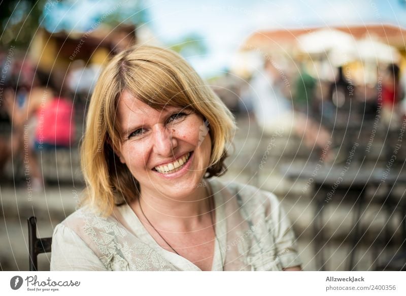 Portrait von einer glücklichen jungen Frau lachend Tag Außenaufnahme Porträt 1 Mensch Junge Frau blond mittellang schulterlang Blick nach vorn positiv