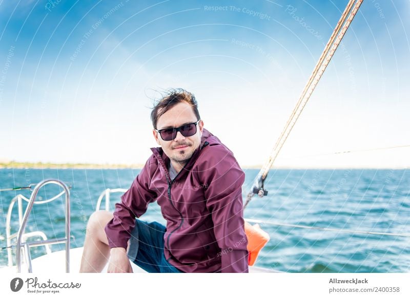 junger Mann sitzt auf einem Segelboot auf dem Meer Tag 1 Mensch Porträt Junger Mann Kurzhaarschnitt Sonnenbrille Wasser Segeln maritim See Blauer Himmel