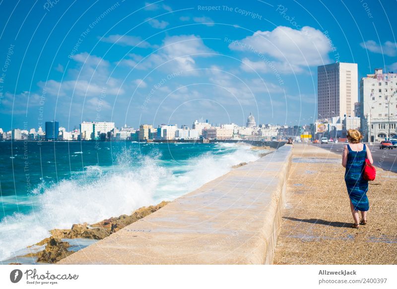 Frau mit blauem Kleid und Hut am Malecon in Havanna Tag Sommer Blauer Himmel Kuba El Malecón Meer Wasser Wellen Gischt Promenade Küste Skyline Wolken