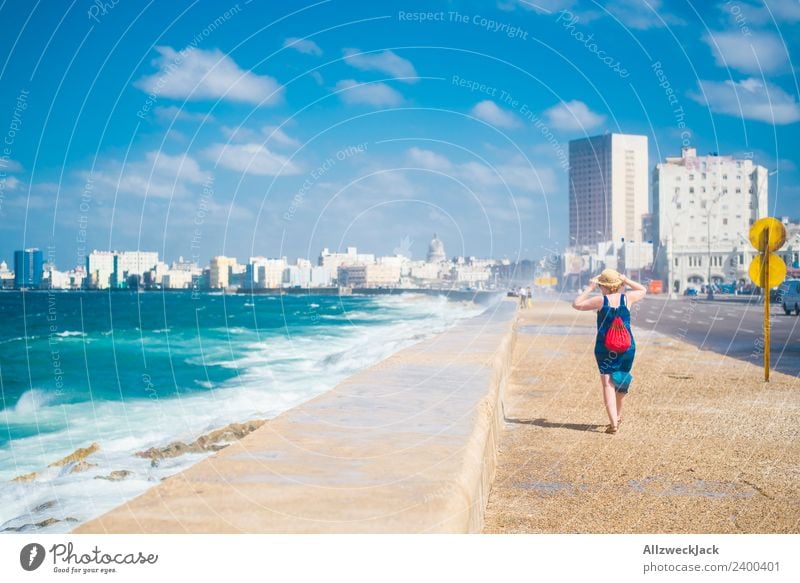 Frau mit blauem Kleid und Hut am Malecon in Havanna Tag Sommer Blauer Himmel Kuba El Malecón Meer Wasser Wellen Gischt Promenade Küste Skyline Wolken