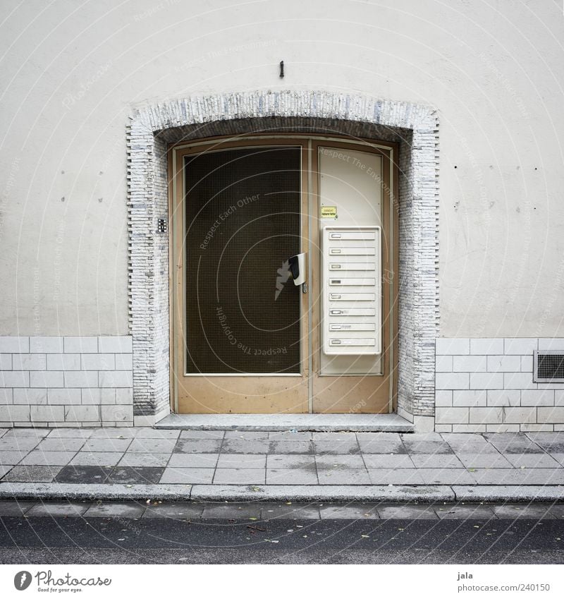 eingang Haus Bauwerk Gebäude Architektur Mauer Wand Fassade Tür Briefkasten Straße Bürgersteig trist grau schwarz Farbfoto Außenaufnahme Menschenleer