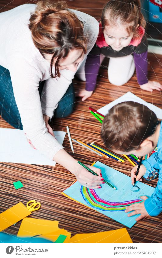 Mama hilft ihrem kleinen Sohn, ein buntes Bild zu zeichnen. Lifestyle Freude Glück Handarbeit Tisch Kindererziehung Bildung Kindergarten Schule Handwerk Mensch