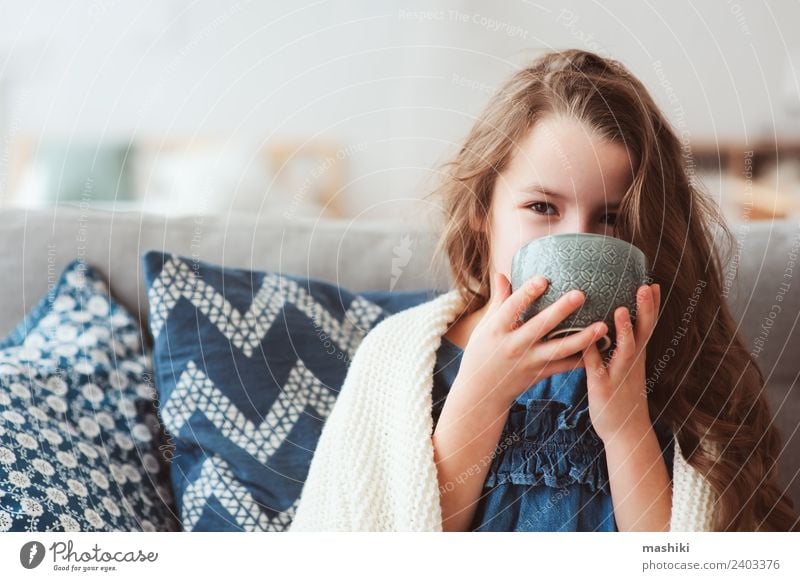 Kind Mädchen trinkt heißen Tee, um sich von der Grippe zu erholen. Krankheit Erholung Winter genießen Lächeln sitzen klein modern natürlich Tradition Gesundheit