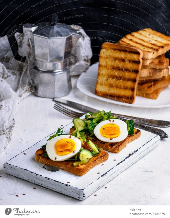 Brot aus Weizenweißmehl mit gekochtem Ei Gemüse Frühstück Mittagessen Abendessen Vegetarische Ernährung Kaffee Teller Gabel Essen frisch lecker braun grün