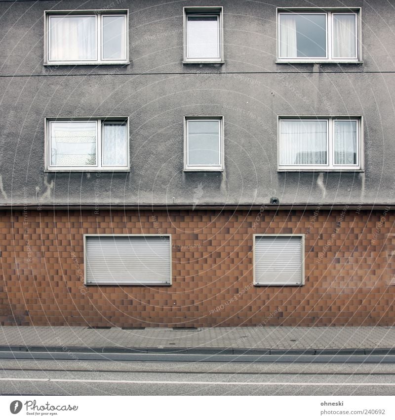 Bonjour Tristesse Haus Bauwerk Gebäude Architektur Mauer Wand Fassade Fenster grau Traurigkeit Sorge Einsamkeit Jalousie Bürgersteig Farbfoto Gedeckte Farben