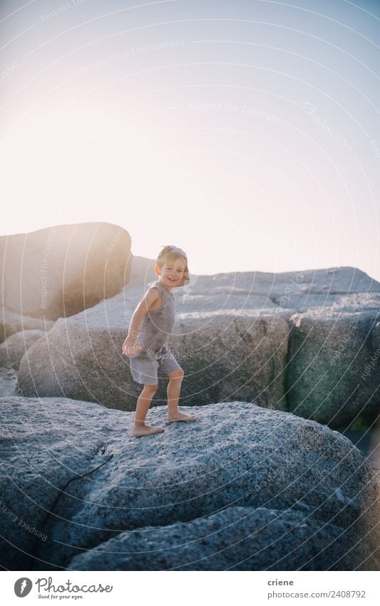 kleiner kaukasischer Junge klettert auf Felsen am Strand. Freude Glück Ferien & Urlaub & Reisen Sommer Sonne Klettern Bergsteigen Kind Kleinkind Kindheit Küste