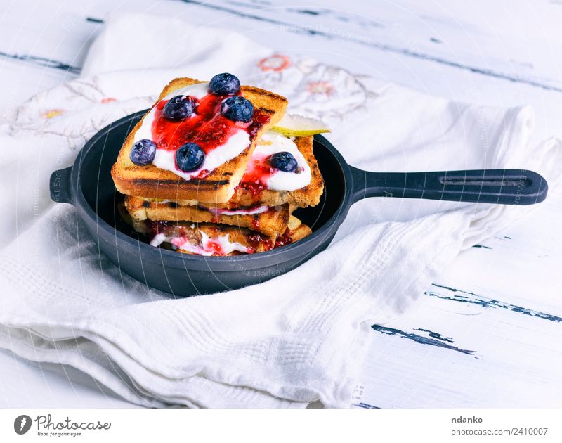 Französischer Toast mit Beeren Frucht Brot Dessert Süßwaren Frühstück Pfanne Tisch frisch lecker weiß Zuprosten Sahne Lebensmittel Hintergrund Gußeisen