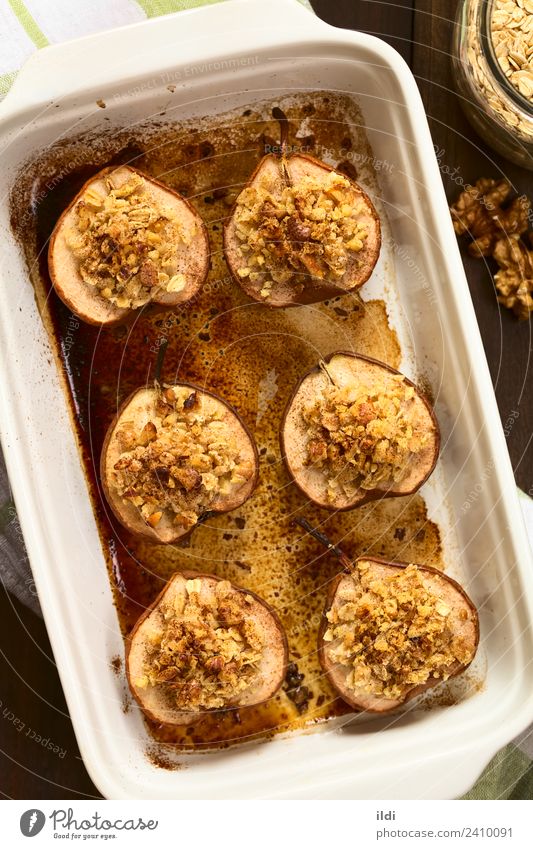 Gebackene Birne mit Haferflockenkruste Frucht Dessert süß Lebensmittel Hälfte Belag gefüllt bröckeln knusprig Kruste Streusel Walnussholz Nut Zucker Zimt Snack