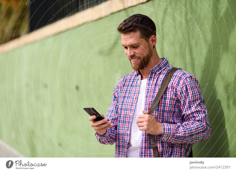 Junger Mann schaut auf sein Smartphone. Lifestyle Stil Glück Ferien & Urlaub & Reisen Telefon PDA Technik & Technologie Mensch Jugendliche Erwachsene 1