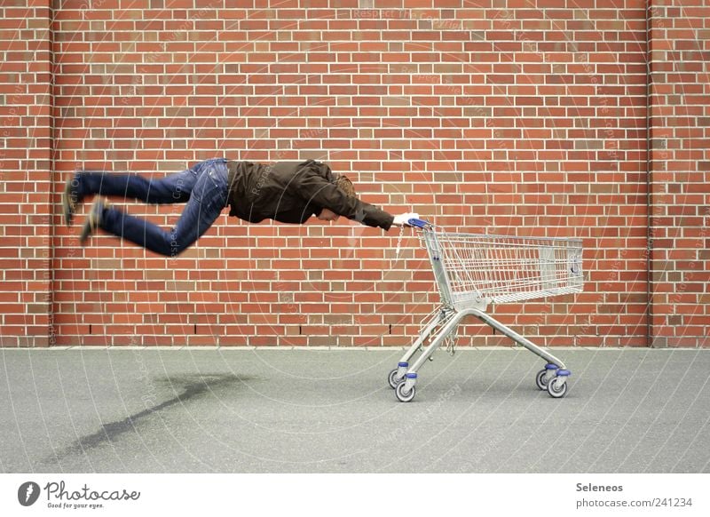 Shoppingwahn Industrie Handel Mensch maskulin Mann Erwachsene 1 Platz Mauer Wand Straße Jeanshose Backstein kaufen fliegen Geschwindigkeit verrückt Bewegung